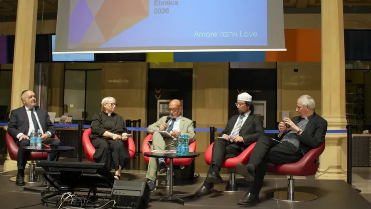 The panel "Children ask, religions answer" on stage at Biblioteca Salaborsa in Bologna, under a screen reading Love.
