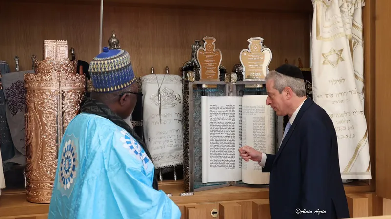Chief Rabbi Moshe Lewin shows an open Torah scroll to Thierno Amadou Ba, Khalif of Bambilor, in the synagogue of the European Centre for Judaism in Paris.