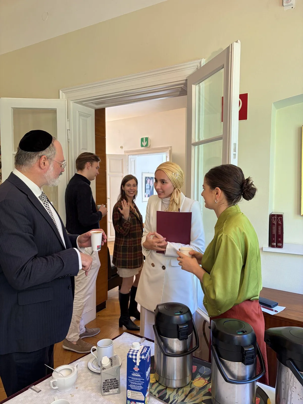 Workshop participants of different faiths talking over coffee during a break at the Bruno Kreisky Forum in Vienna.