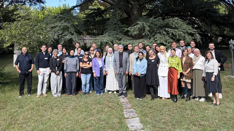 Group photo of the participants of the Bridging Beliefs local workshop in Vienna, standing in a garden under a large cedar tree.